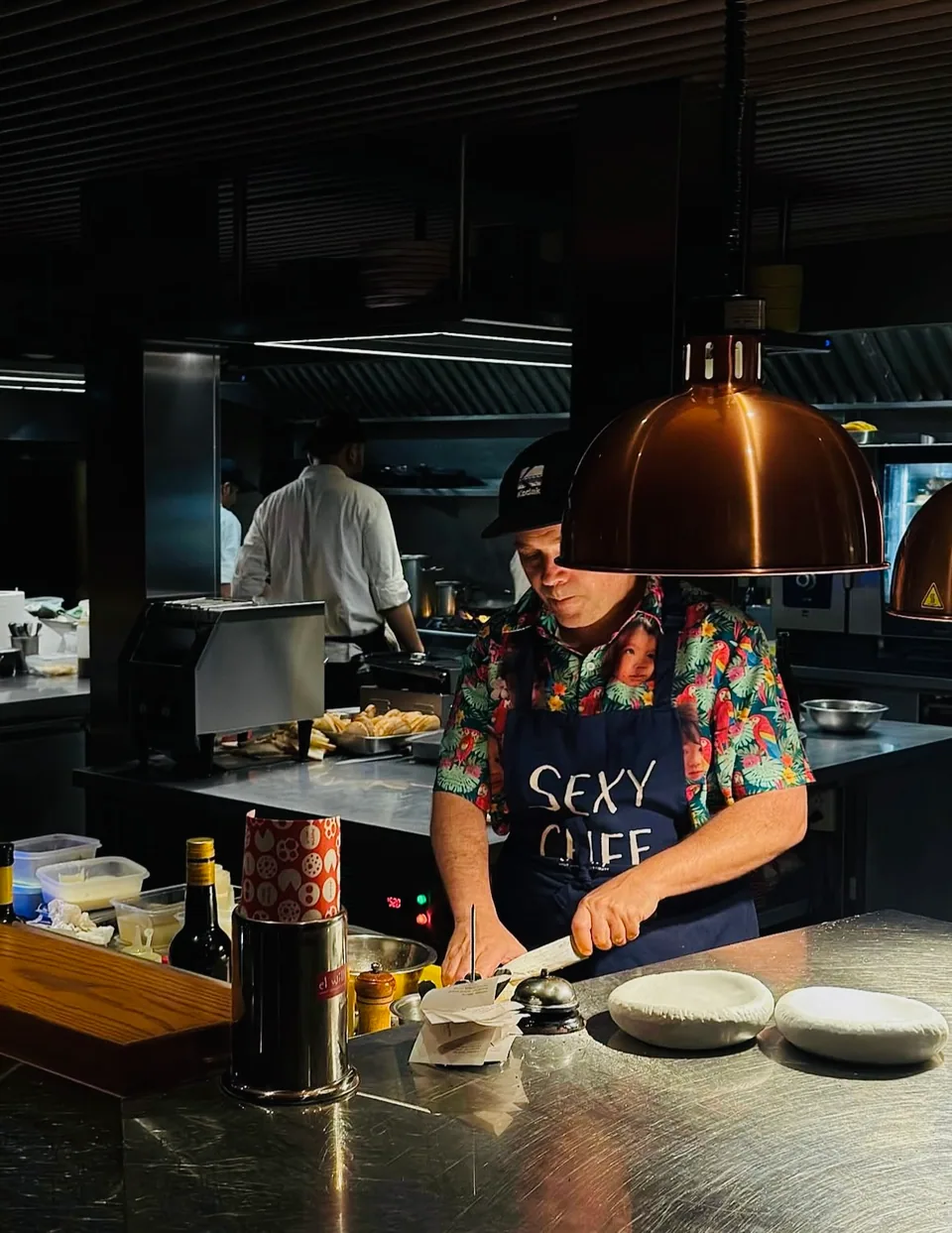 A chef plating dishes in an open kitchen