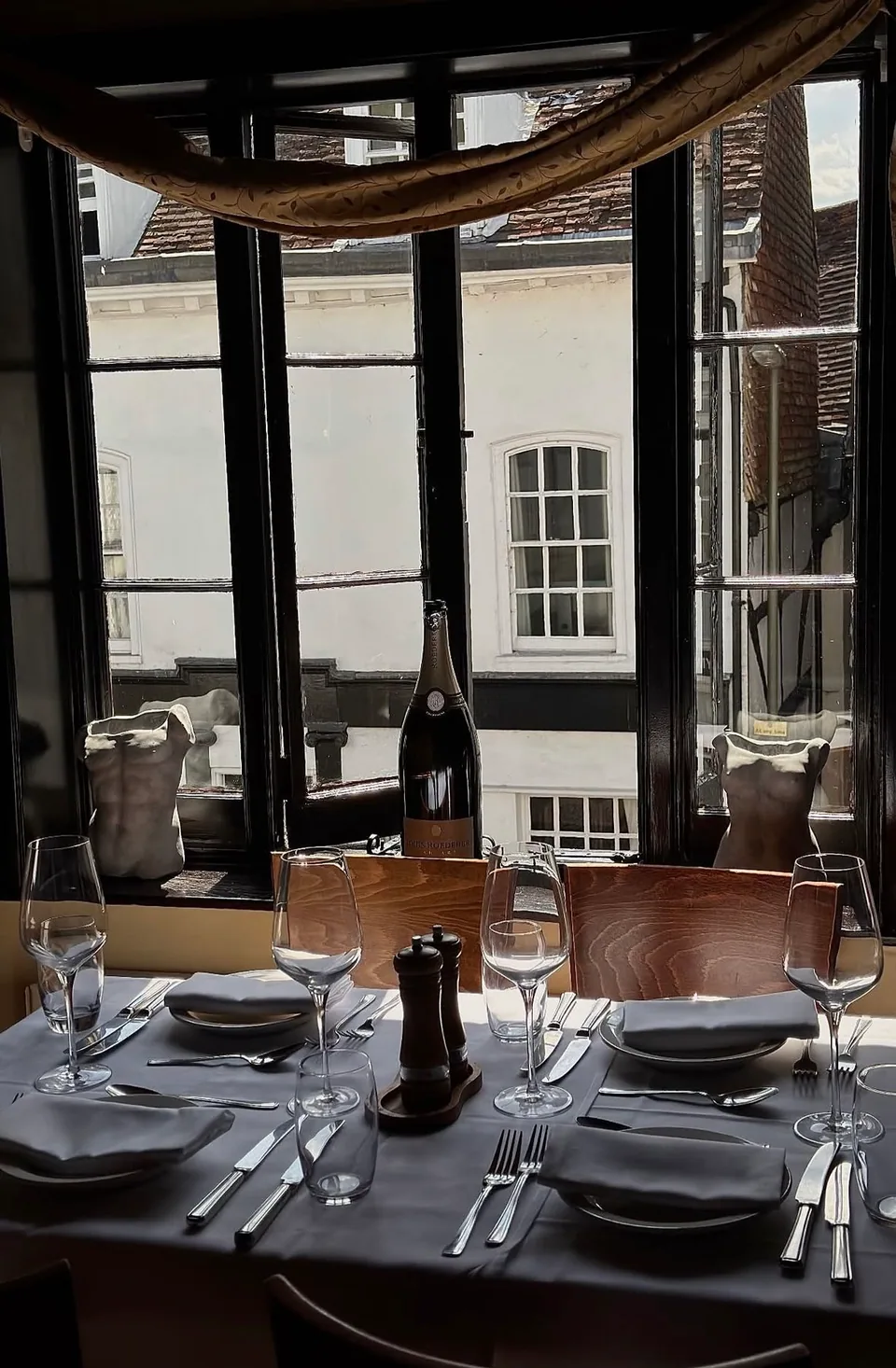 An intimate dining table set beside a sunlit window
