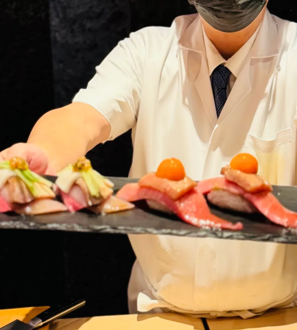 A chef presenting a selection of freshly prepared sushi