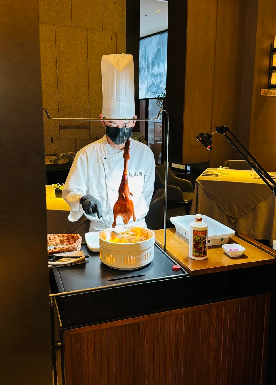 A chef preparing roast duck beside the dining table